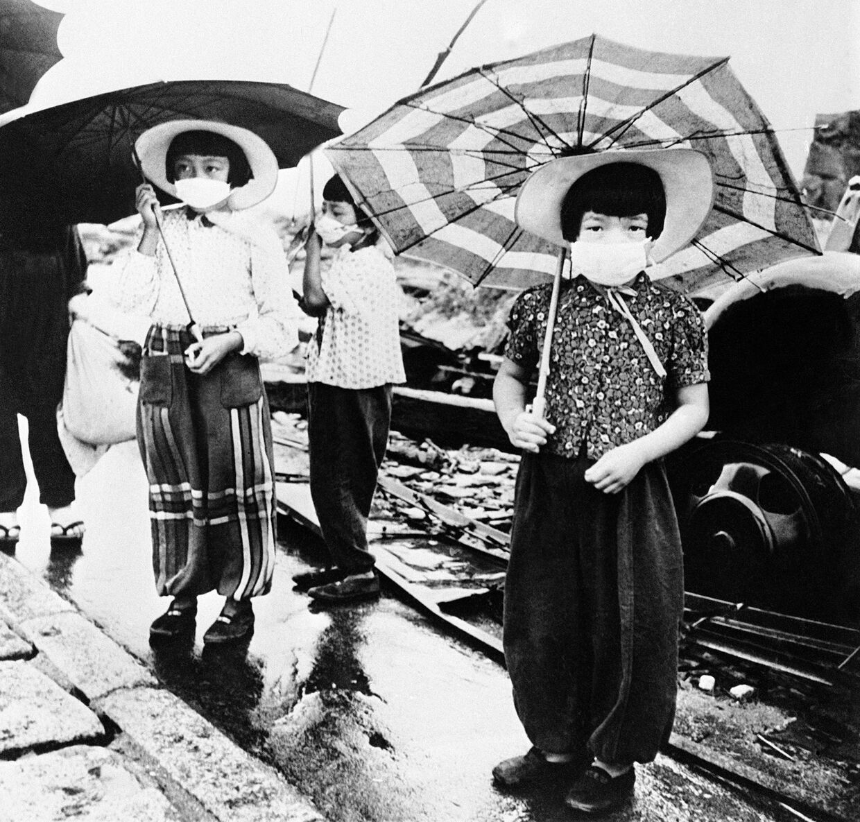 Девочки с марлевыми повязками на лицах на улице Хиросимы, октябрь 1945 года