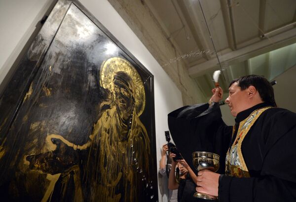 Священнослужитель освящает картину на открытии выставки Духовная брань в ЦСИ Винзавод