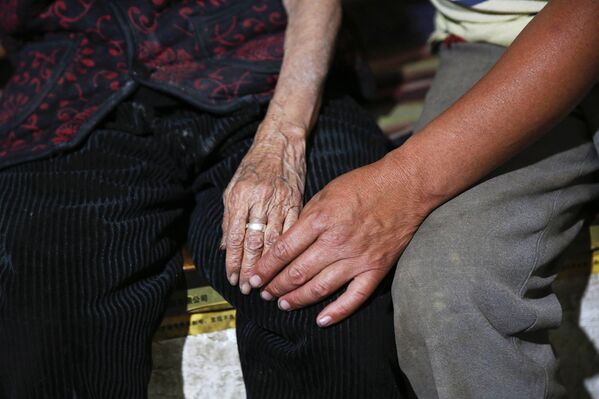Бывшая «женщина для утешения» Хао Цзюйсян держит за руку сына
