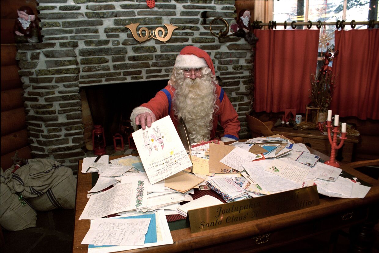 Санта Клаус в своей резиденции разбирает рождественскую почту