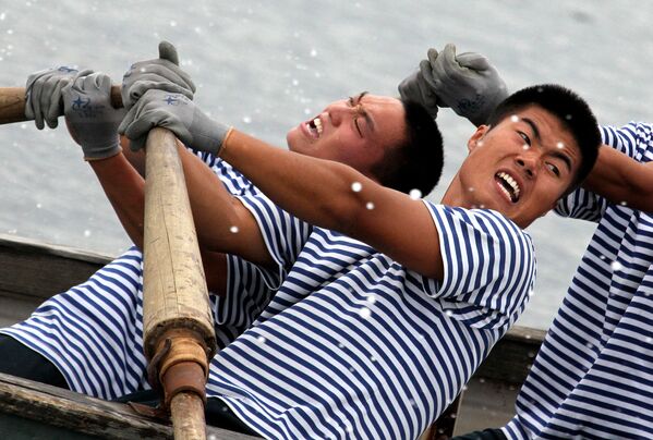 Китайские моряки во время гонки на шлюпках на спортивных состязаниях между российскими и китайскими военными морякам