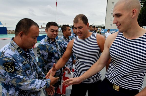 Китайские и российские моряки обмениваются рукопожатиями 