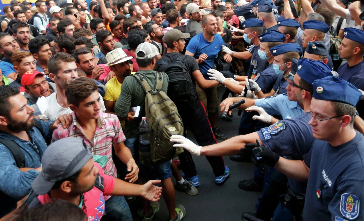 Венгерские полицейские сдерживают беженцев на железнодорожном вокзале Будапешта, Венгрия. 1 сентября 2015