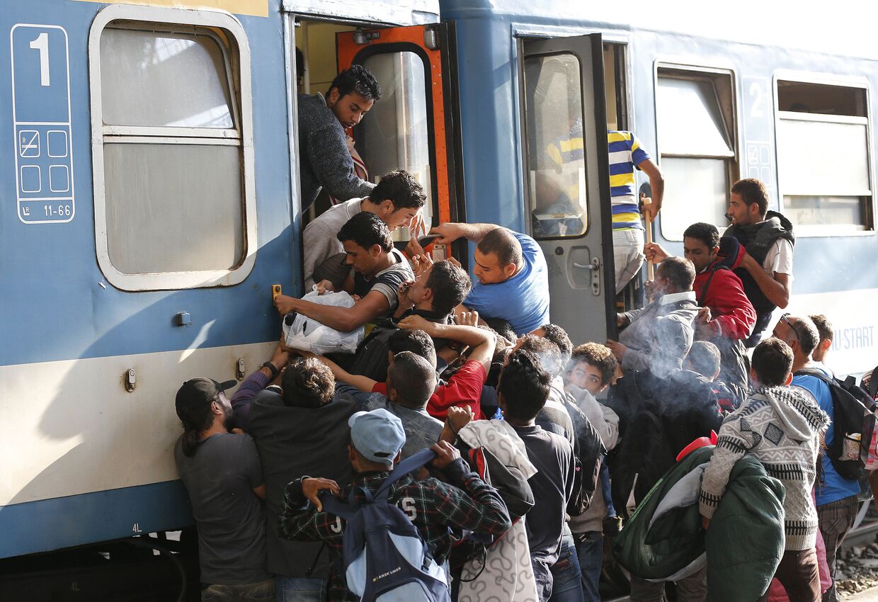 Беженцы пытаются попасть в поезд на железнодорожной станции в Будапеште