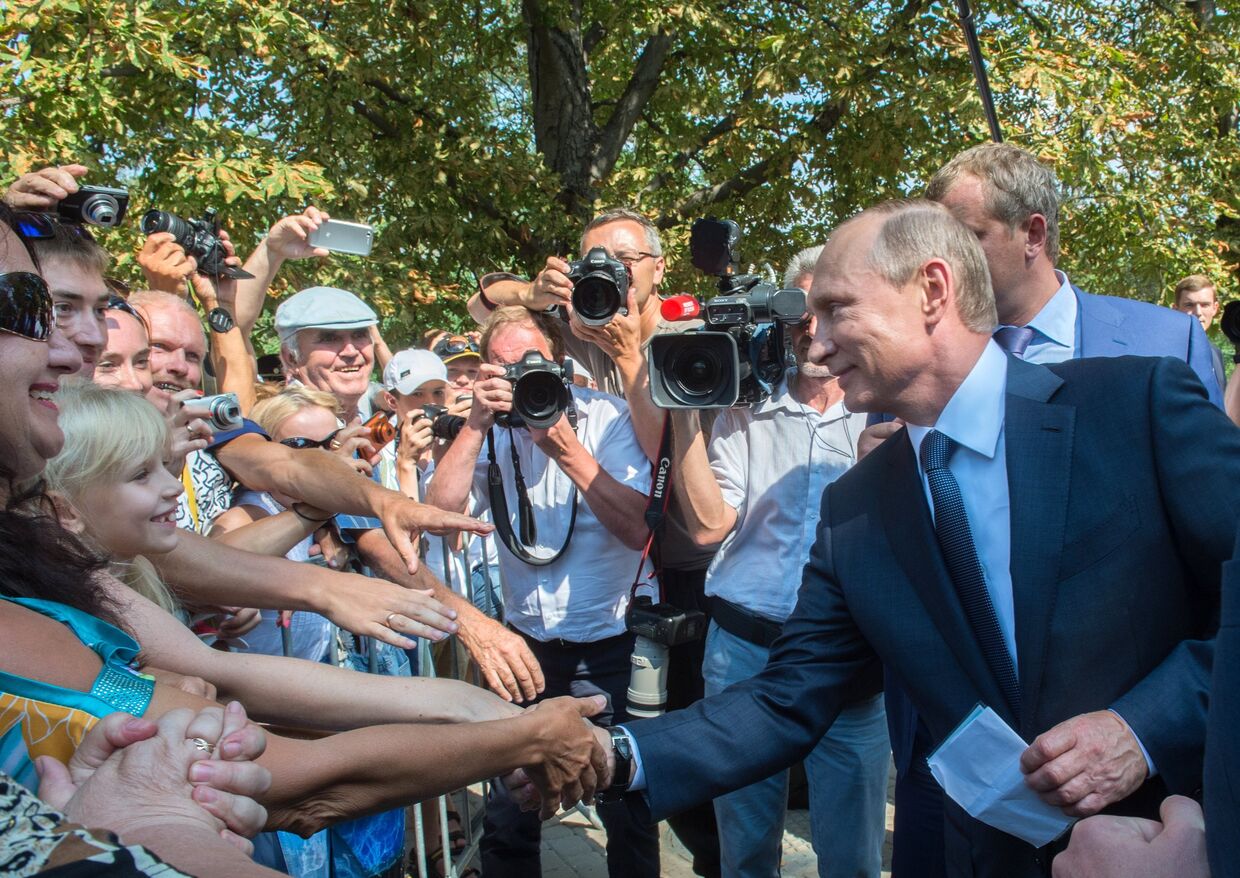 Президент России Владимир Путин общается с отдыхающими и местными жителями во время посещения мемориального комплекса Малахов курган в Севастополе