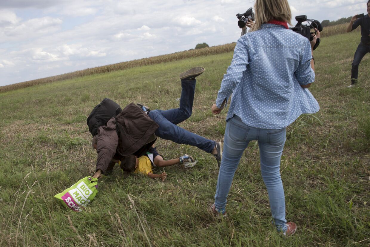 Женщина-оператор N1TV ставит подножку беженцу на границе Сербии и Венгрии