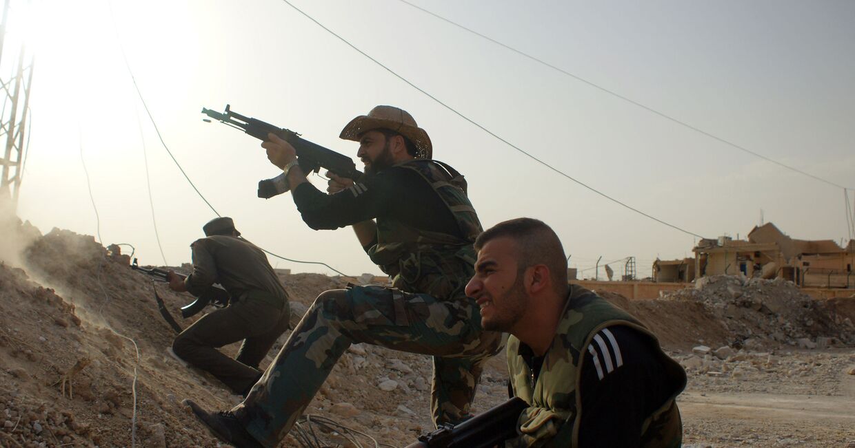 Сирийские военные и ополченцы ведут бой с боевиками ИГИЛ на окраине города Эль-Хасака (Хасеке) на востоке Сирии