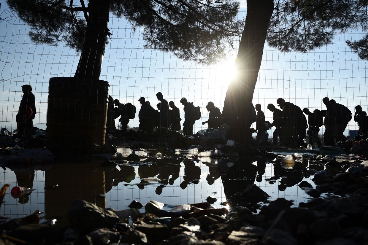 Беженцы идут из деревни Идомени на севере Греции в сторону Македонии 
