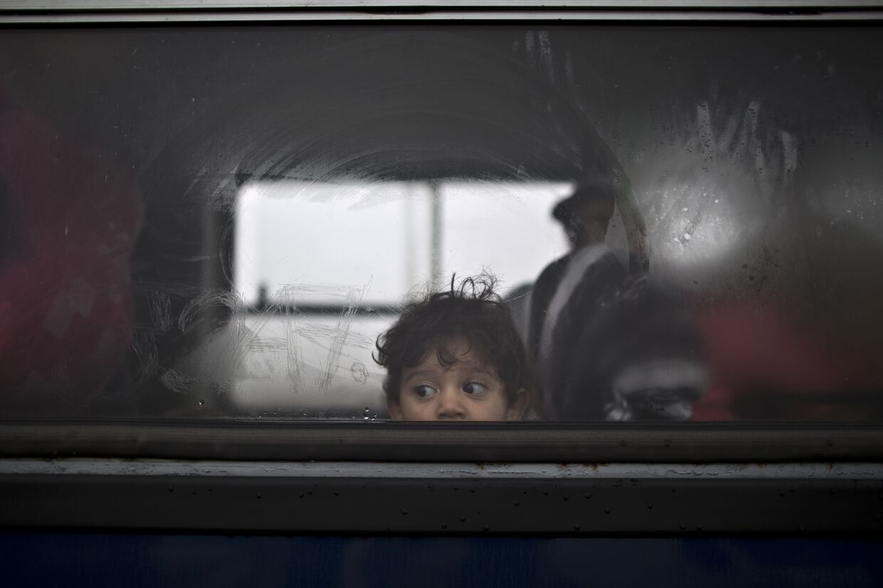 Ребенок из Сирии в автобусе, который отвезет его семью в лагерь для беженцев неподалеку от города Рёске, южная Венгрия