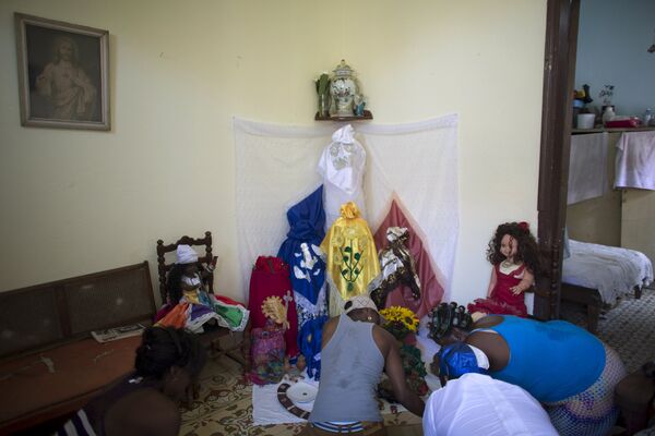 Последователи сантерии молятся перед ритуалом кабильдо