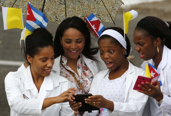 Медсестры с флагами Кубы и Ватикана в волосах ждут проезда папамобиля