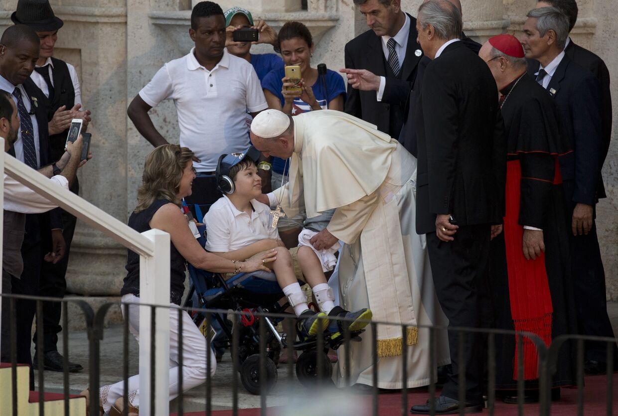 Папа Франциск разговаривает с мальчиком на инвалидной коляске во время встречи с молодежью в Гаване