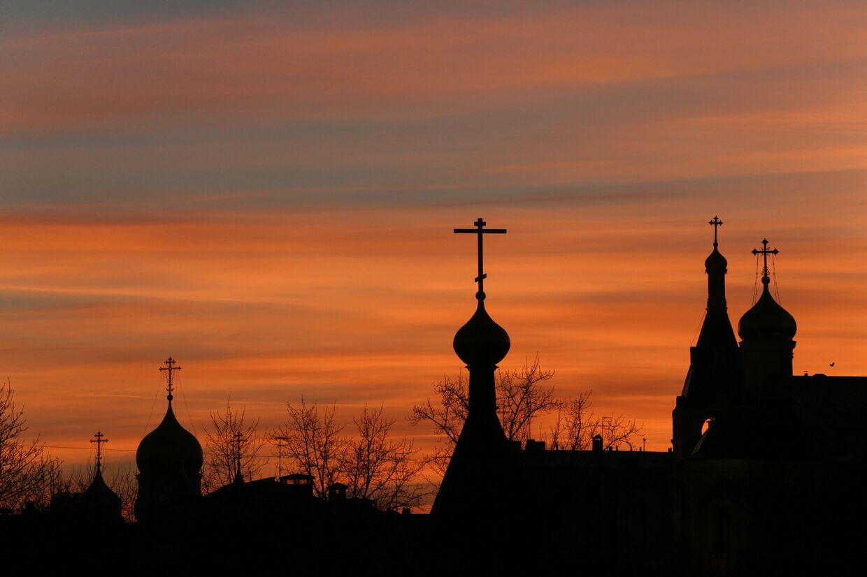 Силуэты церквей в центре Москвы на фоне закатного неба