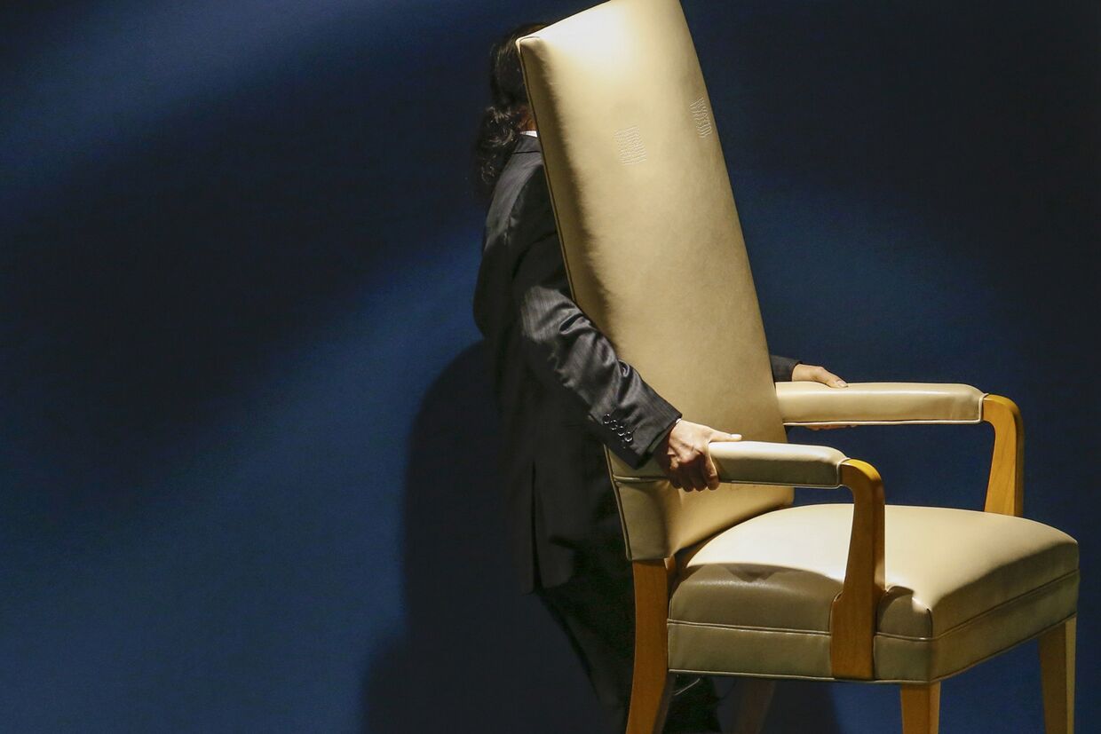 Сотрудник выносит стул для делегатов, которые будут выступать на 70-й сессии Генассамблеи ООН