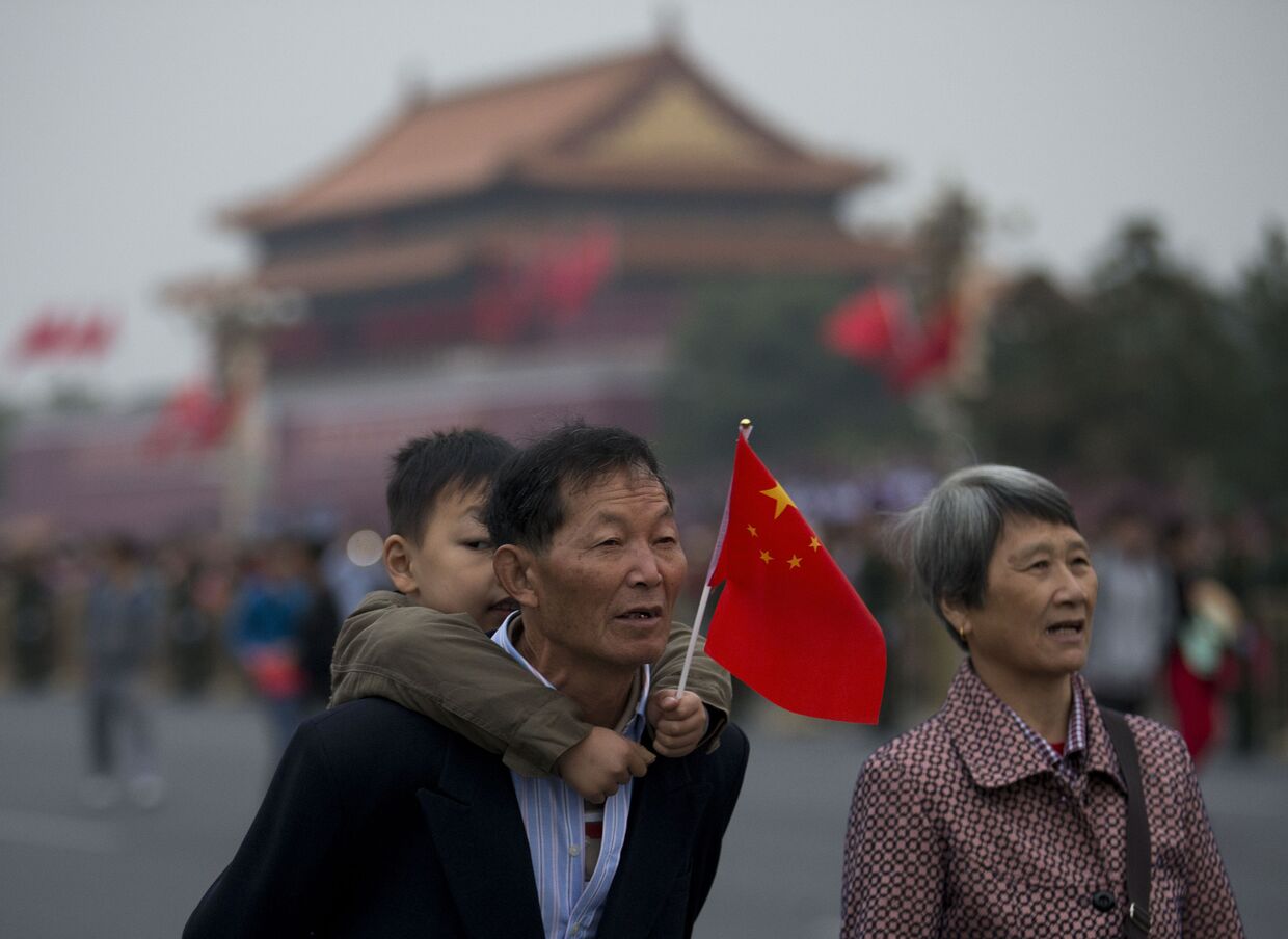 Пожилая пара с ребенком на площади Тяньаньмэнь в Китае