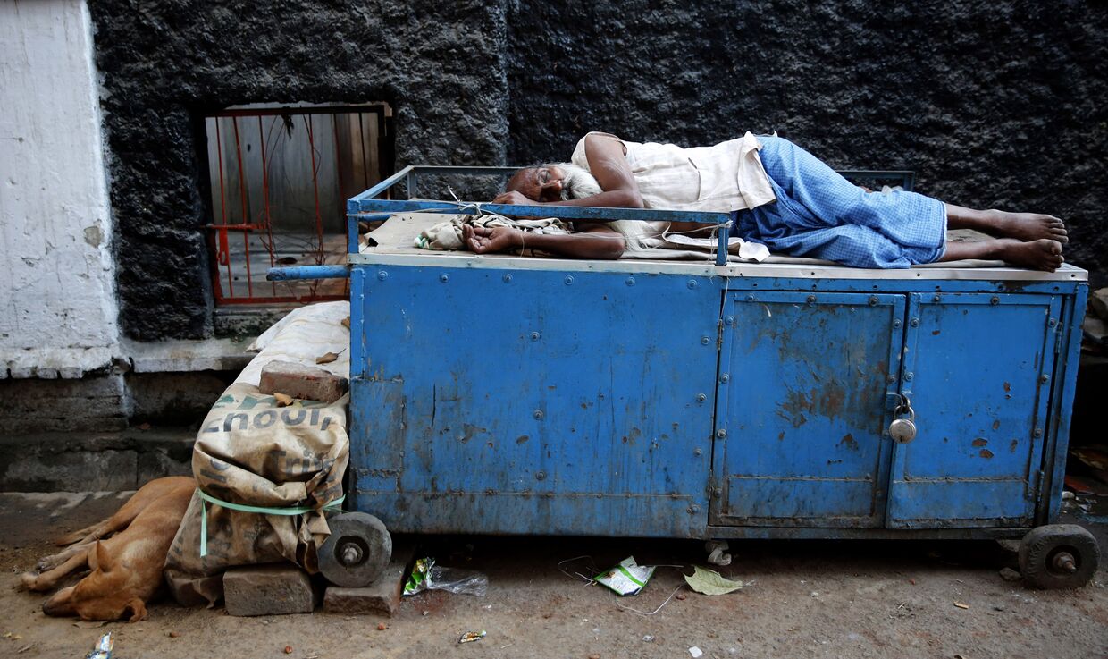 Спящий продавец чая на улице в Аллахабаде, Индия