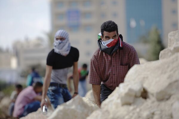 Палестинцы во время столкновений с израильскими полицейскими рядом с городом Рамалла
