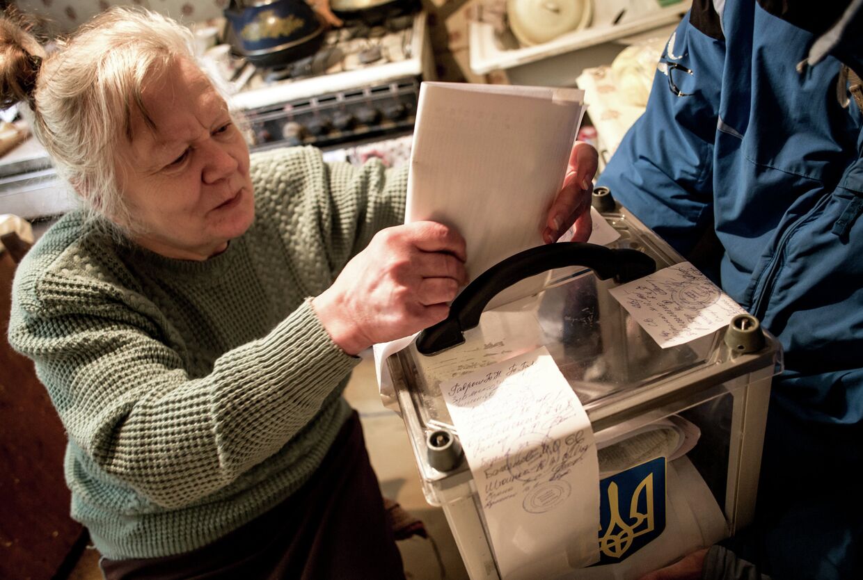 Пожилая женщина голосует на дому в Харькове во время выборов в органы местного самоуправления