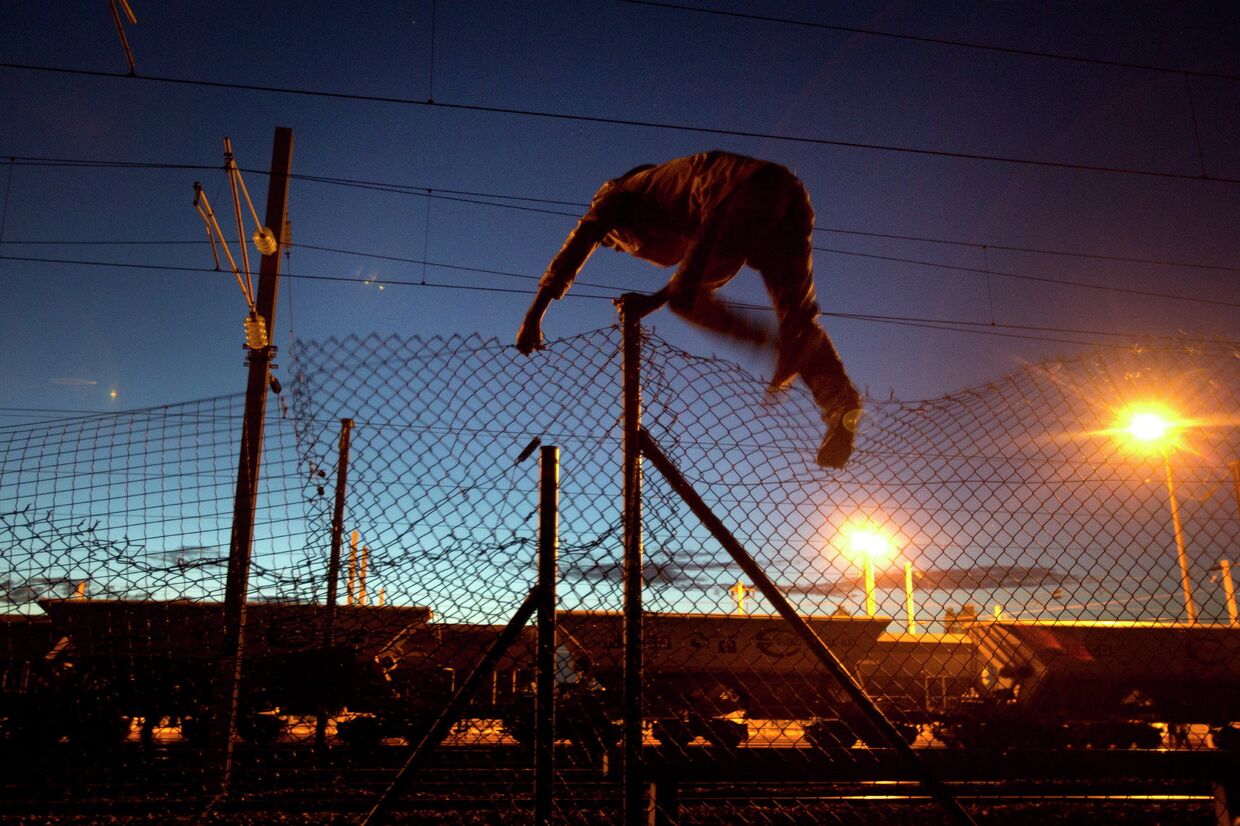 Мигрант пытается пробраться в Евротоннель в Кале, Франция