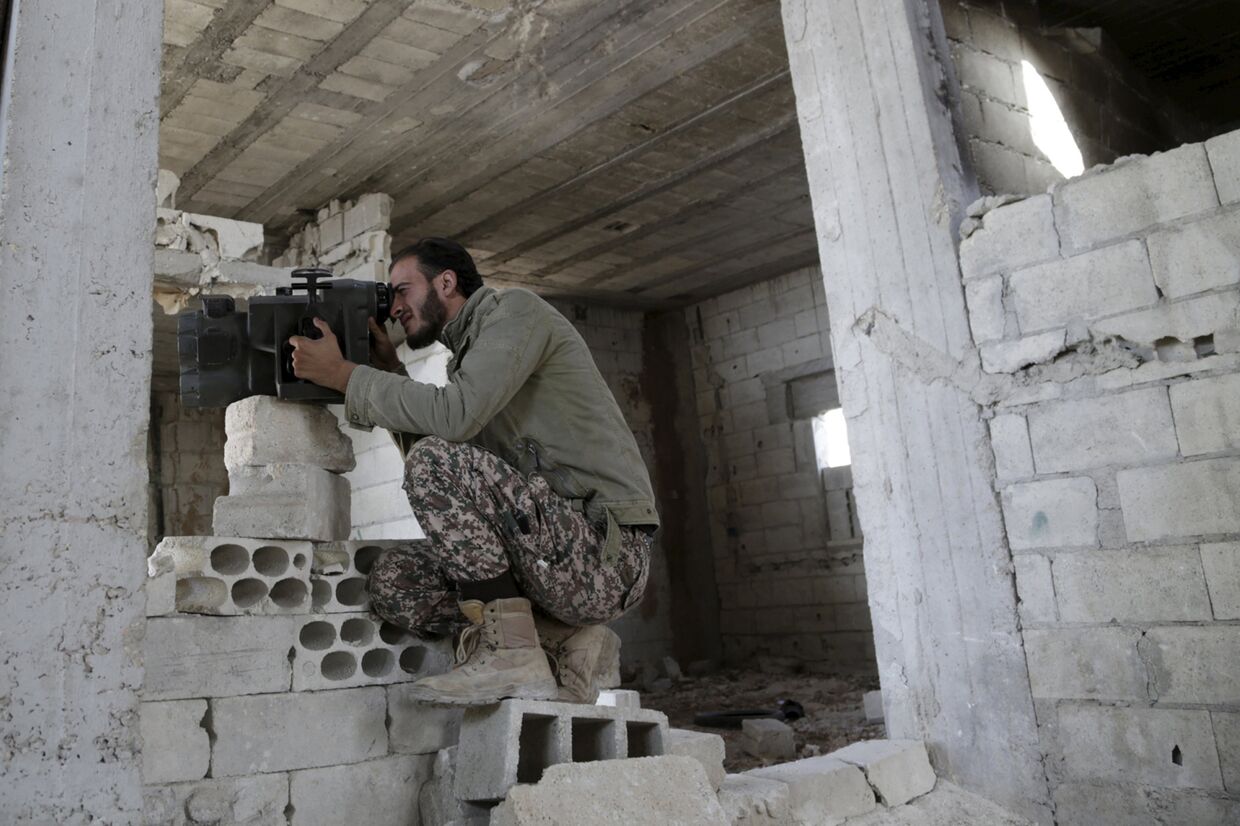 Боец Свободной сирийской армии мониторит позиции сил, поддерживающих Башара Асада, в провинции Хама на севере Сирии, 14 октября 2015 года