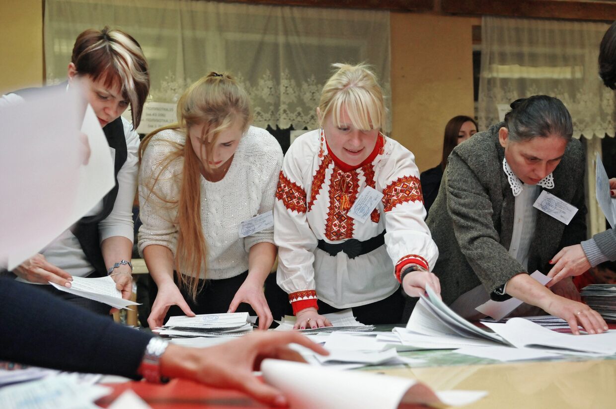 Сотрудники участковой избирательной комиссии на одном из избирательных участков Львова во время подсчета голосов на выборах
