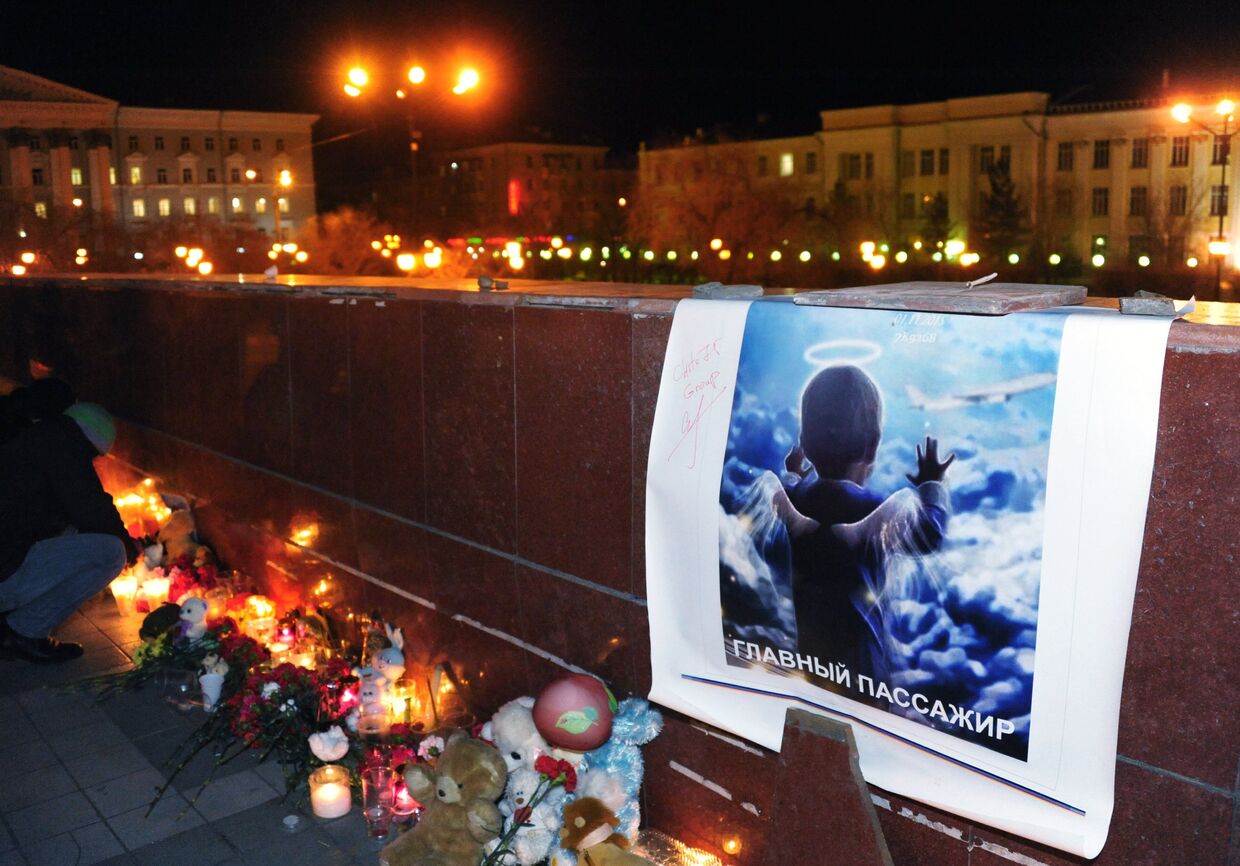 Свечи, игрушки и цветы на площади Ленина в Чите во время акции памяти жертв крушения самолета А-321