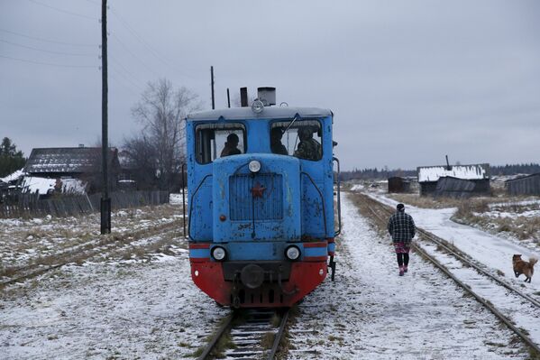 Женщина из деревни Муратково Свердловской области разговаривает с машинистом поезда, который отвозит детей в школу в Санкино