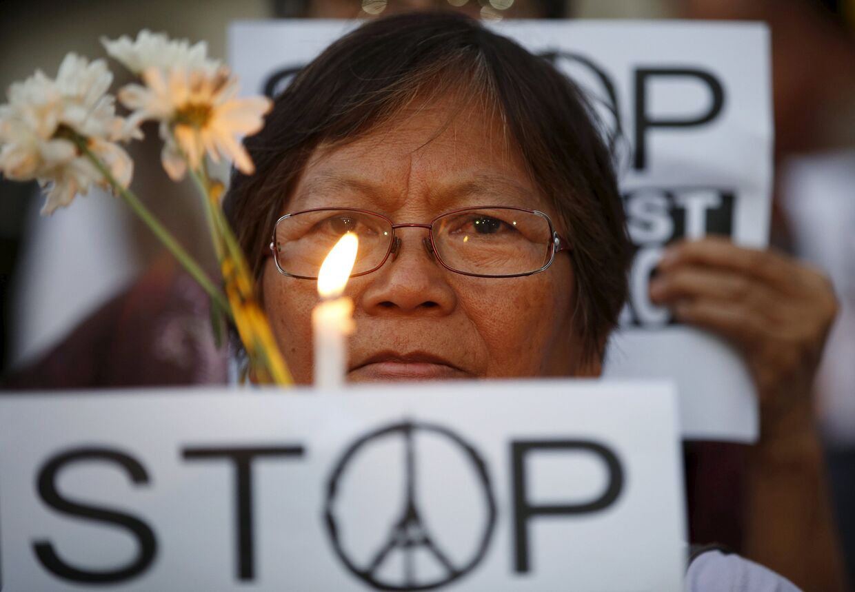 Женщина на акции, посвященной памяти погибших в парижских терактах, в Маниле