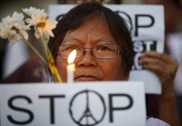 Женщина на акции, посвященной памяти погибших в парижских терактах, в Маниле