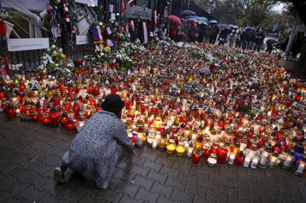 Цветы и свечи в память о погибших во время терактов в Париже у французского посольства в Варшаве