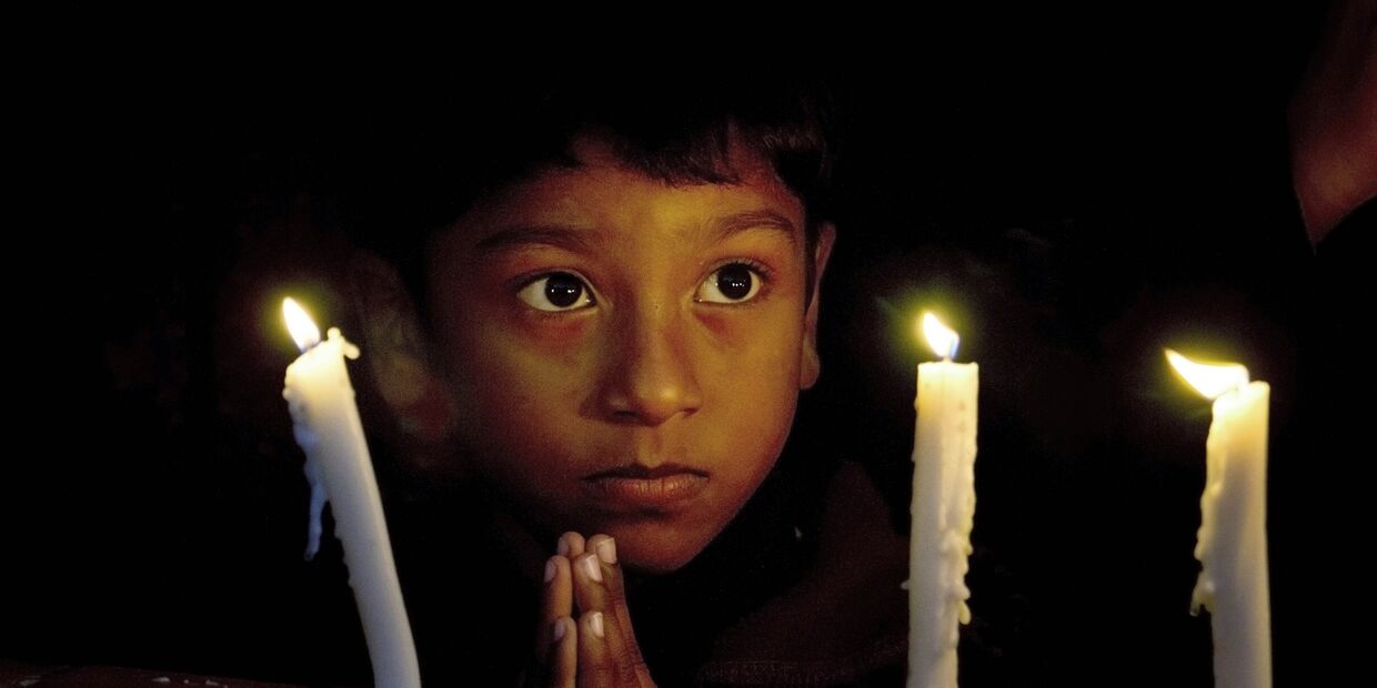Мальчик во время службы, посвященной погибшим в парижских терактах, в христианской церкви в Исламабаде