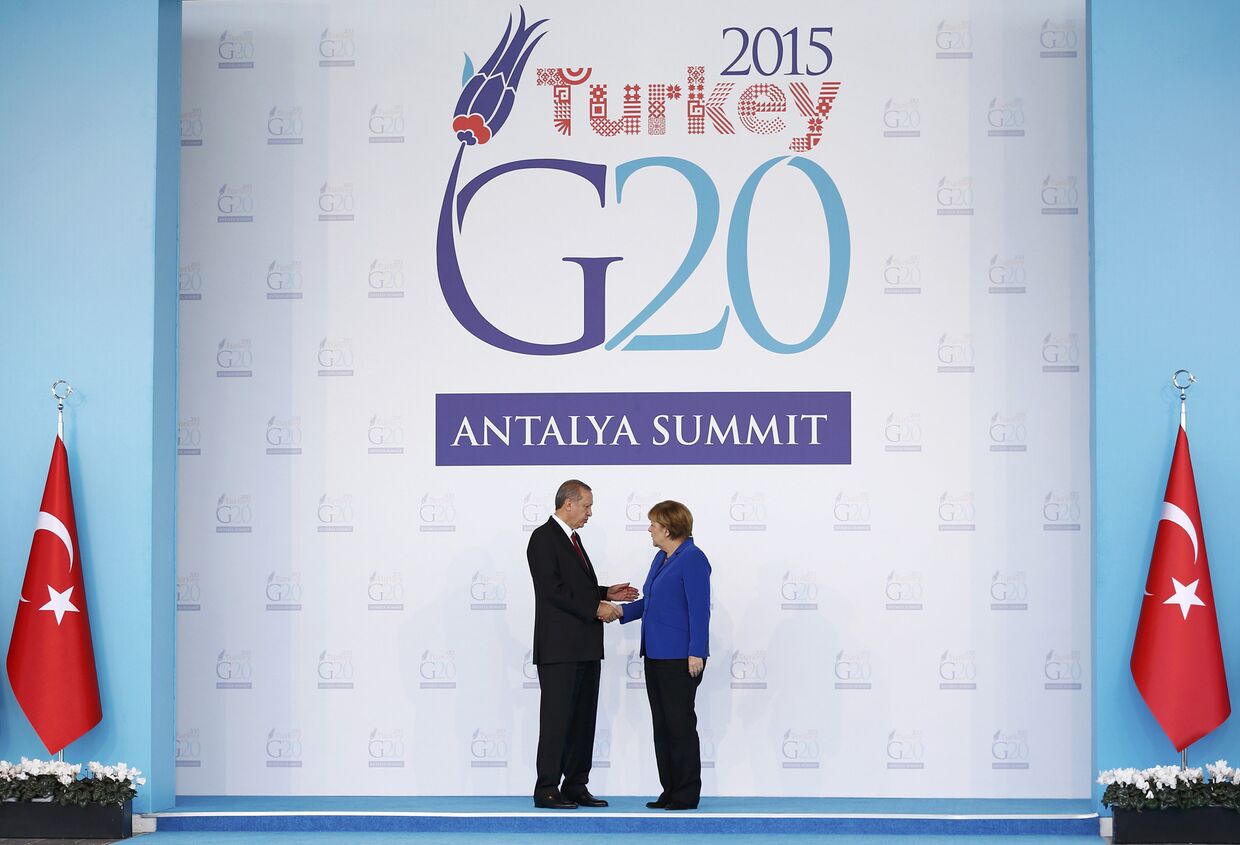 Президент Турции Реджеп Тайип Эрдоган приветствует канцлера ФРГ Ангелу Меркель на саммите G20 в Анталье