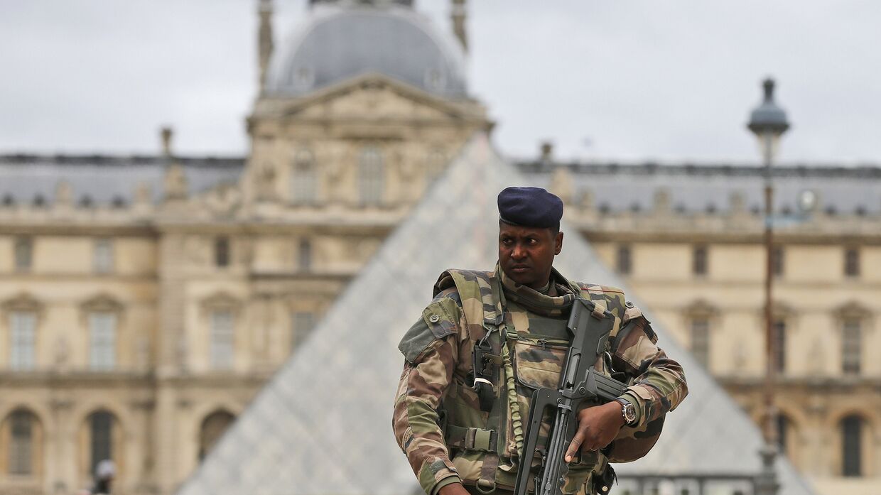 Солдат патрулирует внутренний двор Лувра