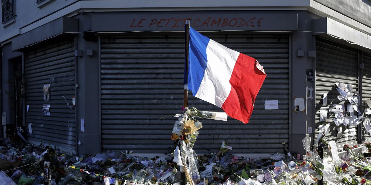 Флаг Франции и цвета у входа в ресторан Le Petit Cambodge в Париже, где произошел теракт
