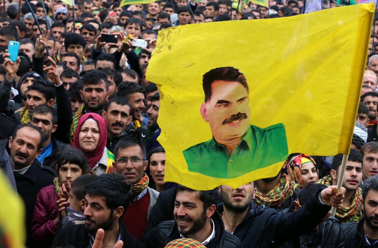 Сторонник Рабочей партии Курдистана держит флаг с портретом ее лидера Абдуллы Оджаллана во время празднования Навруза в городе Диярбакыр