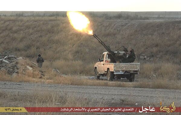 Боевики «Исламского государства» стреляют из зенитного орудия в городе Хассакех на северо-востоке Сирии