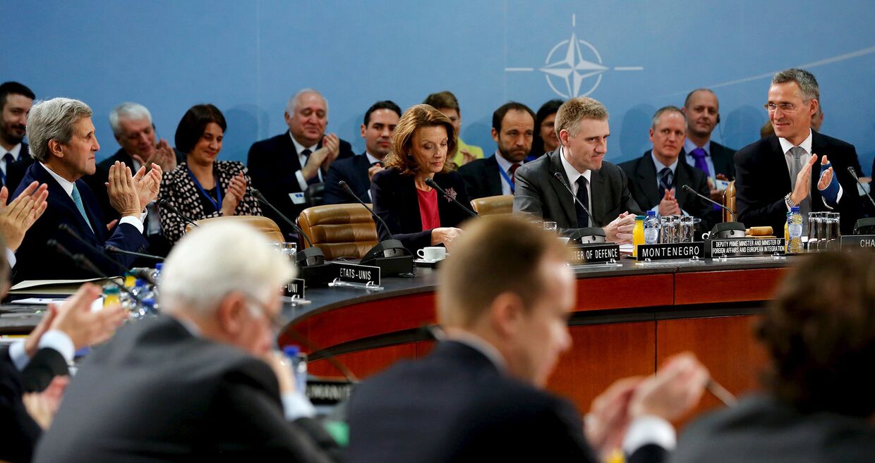 Йенс Столтенберг и другие участники встречи министров иностранных дел стран НАТО в Брюсселе аплодируют министру иностранных дел Черногории Игора Лукшича