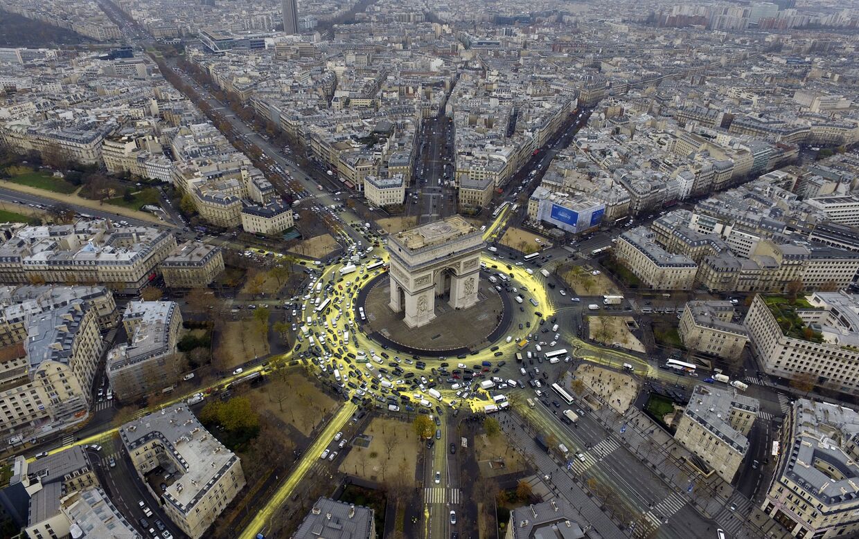 Улицы вокруг Триумфальной арки в Париже, выкрашенные в желтый цвет активистами Greenpeace