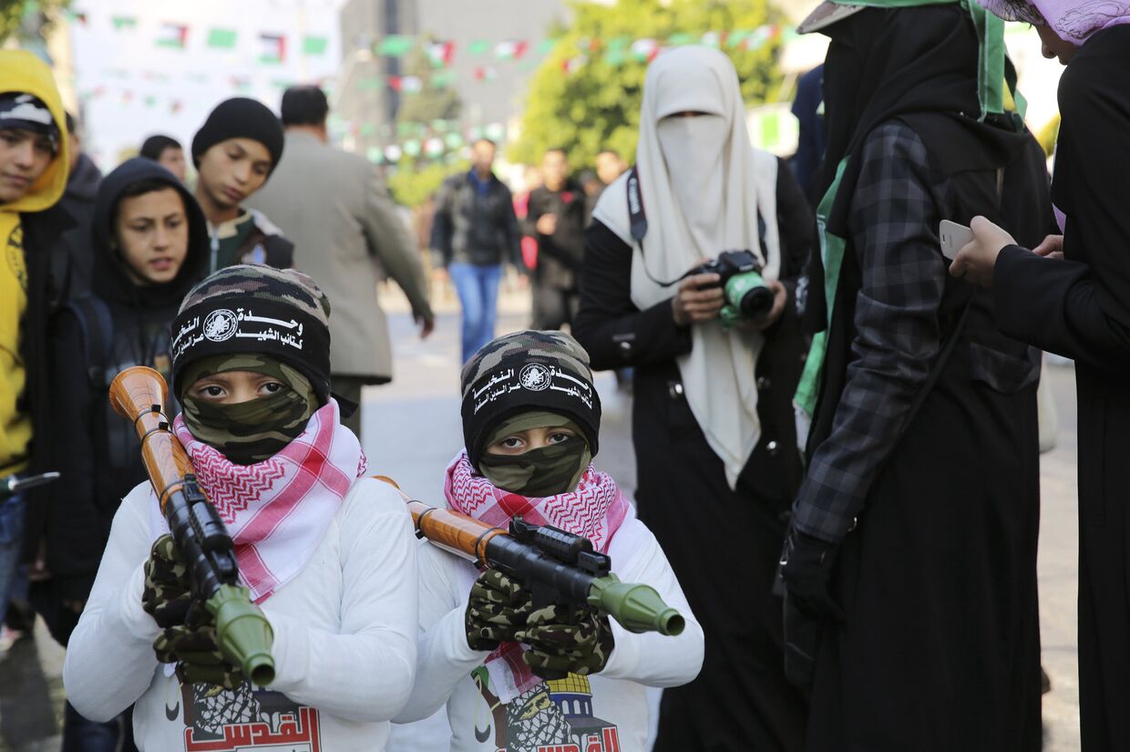 Дети с игрушечным оружием о время парада в Газе в честь 28-летия основания движения ХАМАС