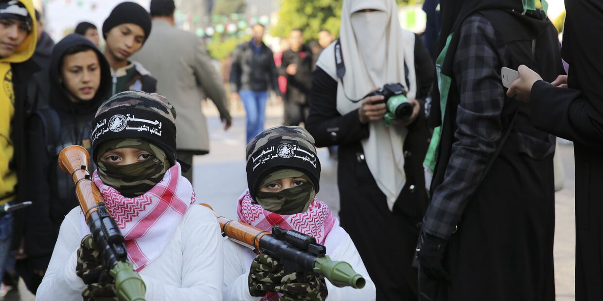 Дети с игрушечным оружием о время парада в Газе в честь 28-летия основания движения ХАМАС