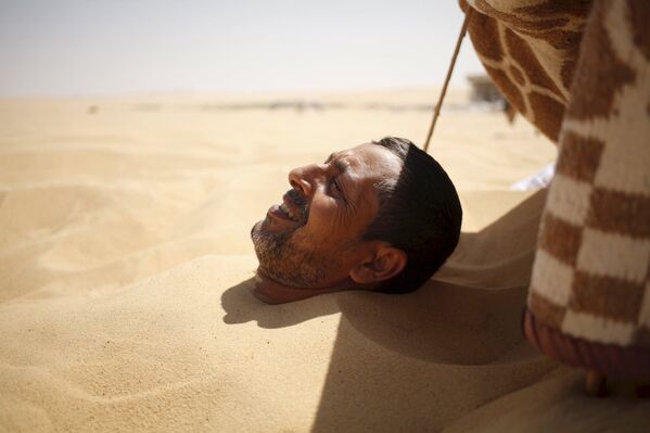 Закапывание в горячий песок в Сиве, Египет