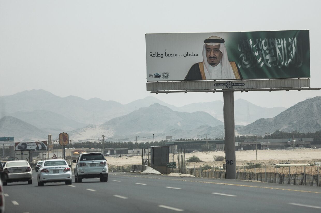 Щит с портретом короля Салмана и словами «Салман, мы слушаем и повинуемся» у шоссе поблизости от Мекки