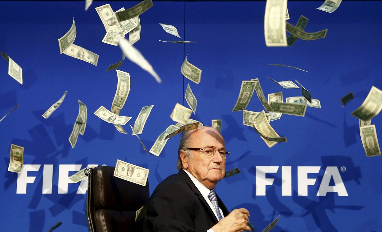 Комик Ли Нельсон бросает банкноты в президента ФИФА Зеппа Блаттера во время пресс-конференции в штаб-квартире ФИФА в Цюрихе