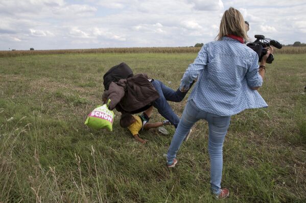 Женщина-оператор N1TV ставит подножку беженцу на границе Сербии и Венгрии