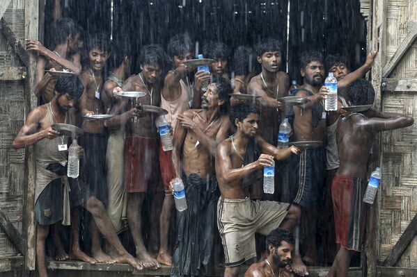 Мигранты, живущие во временном лагере в Мьянме, собирают дождевую воду