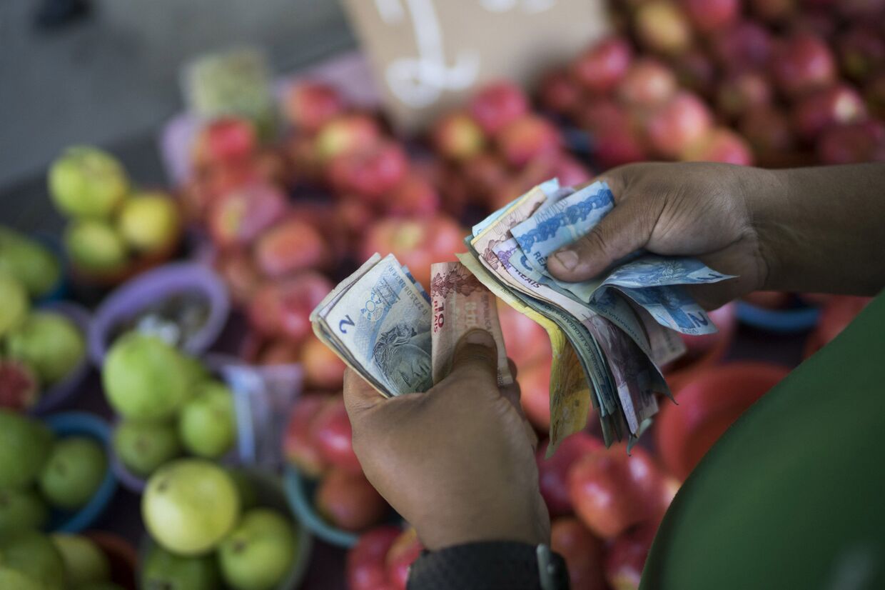 Продавец фруктов в Рио-да-Жанейро считает деньги