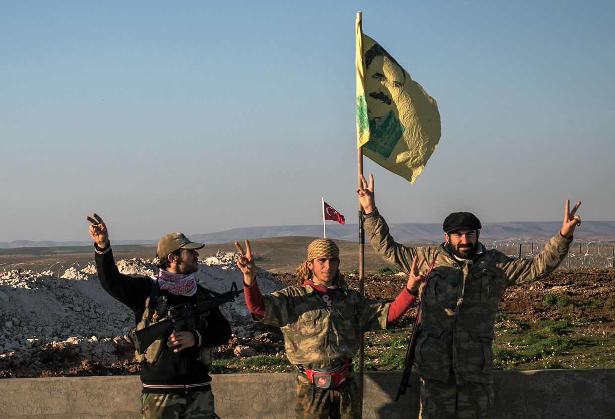 Бойцы курдских Отрядов народной самообороны (YPG) с портретом лидера Рабочей партии Курдистана Абдуллы Оджалана