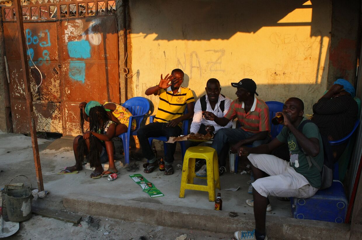 Местные жители отдыхают на одной из улиц города Луанда