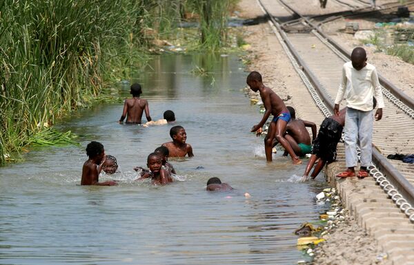 Дети купаются возле железной дороги в городе Луанда Дети купаются возле железной дороги в городе Луанда