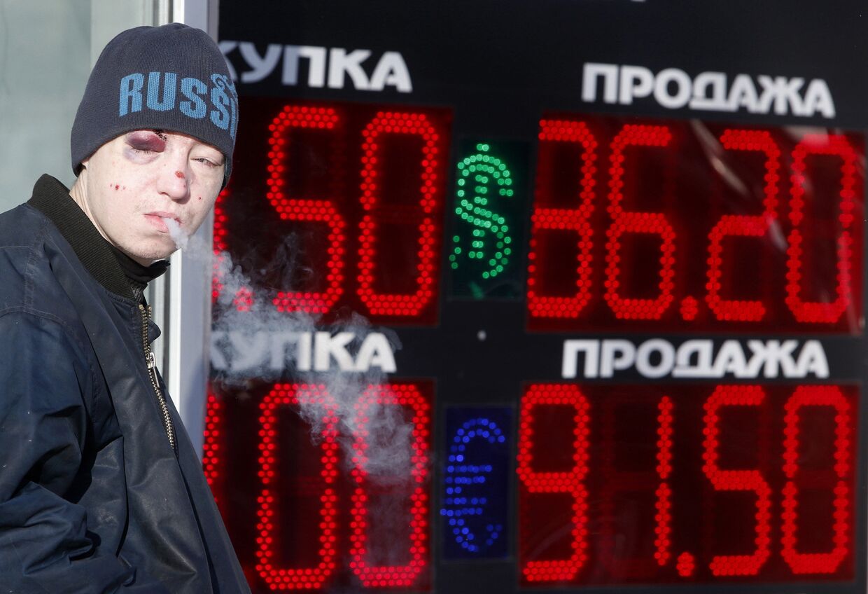 Мужчина у табло с курсами обмена валют в Москве